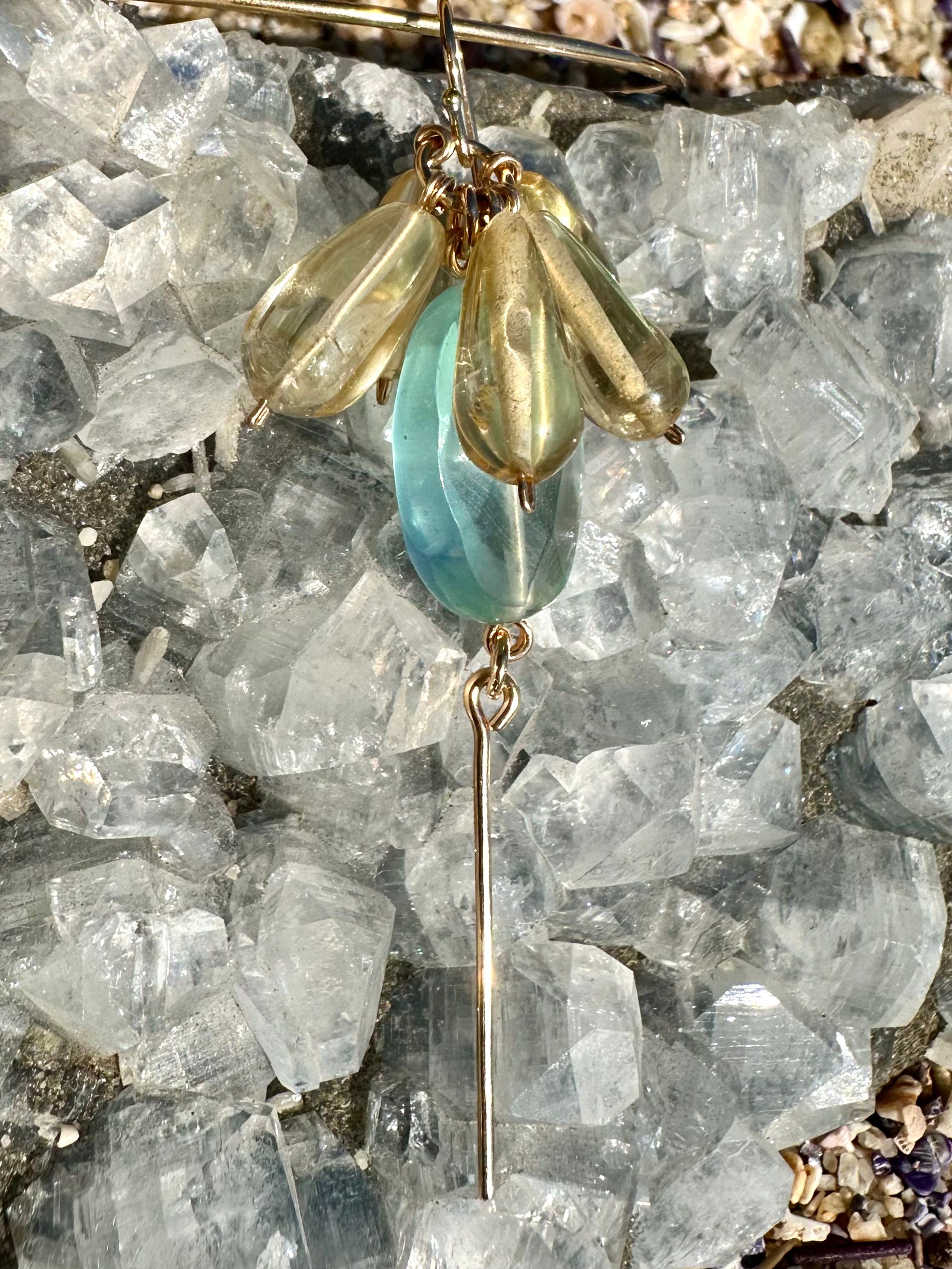 Apricity drop earrings, gemstone drop earrings, earrings in gold on crystal close-up
