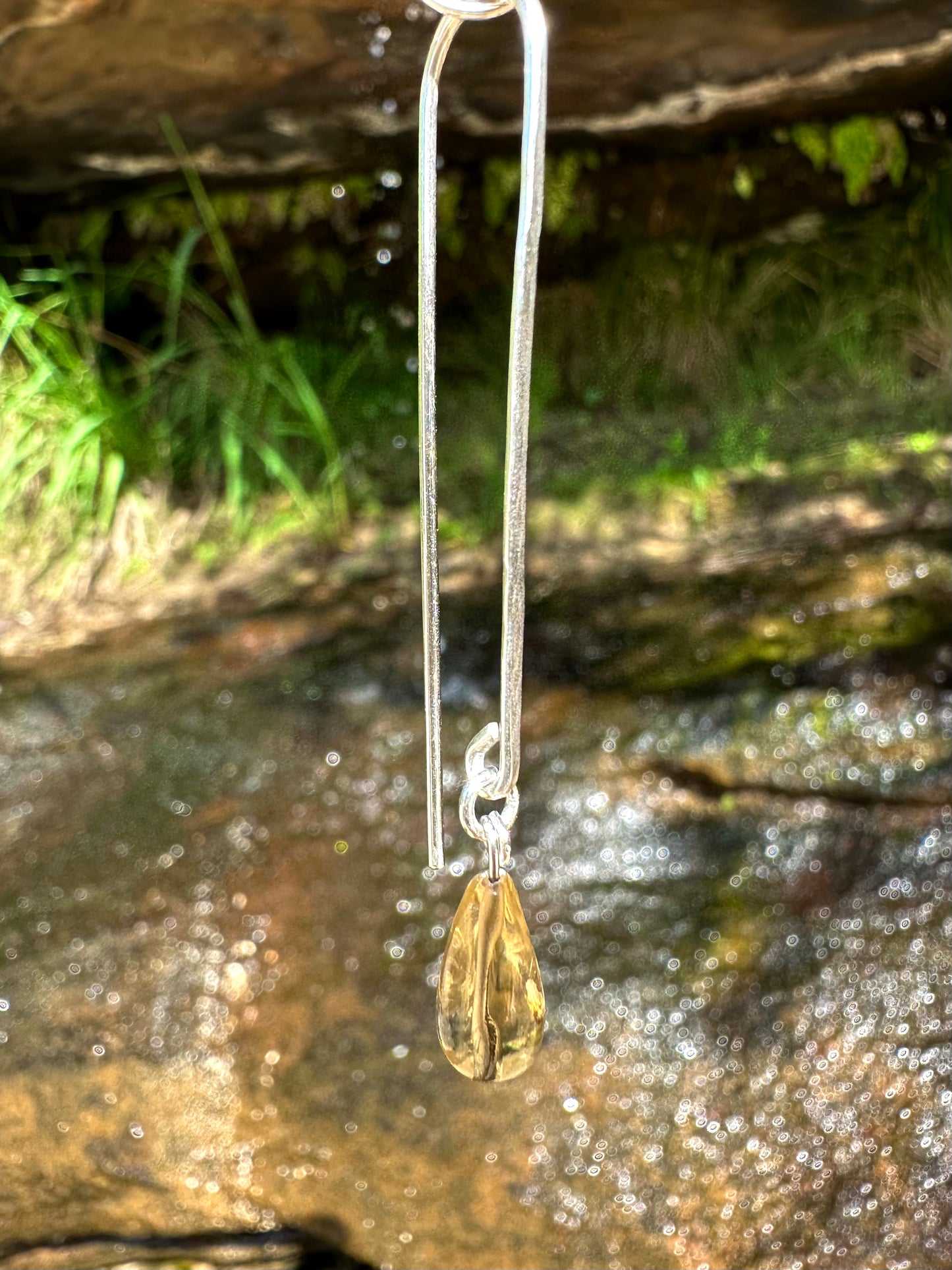 Lily pin drop earrings, citrine earrings, citrine earrings in silver in front of waterfall