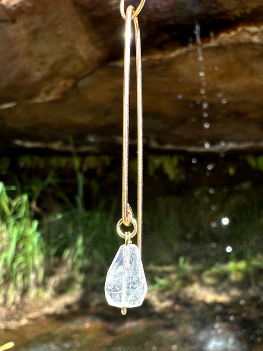 Lily pin drop earrings, aquamarine drop earrings, aquamarine earrings in gold in front of waterfall