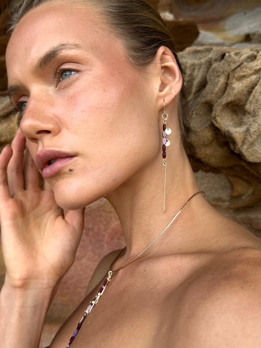 Aphrodite drop earrings, garnet earrings, earrings in gold on model close-up