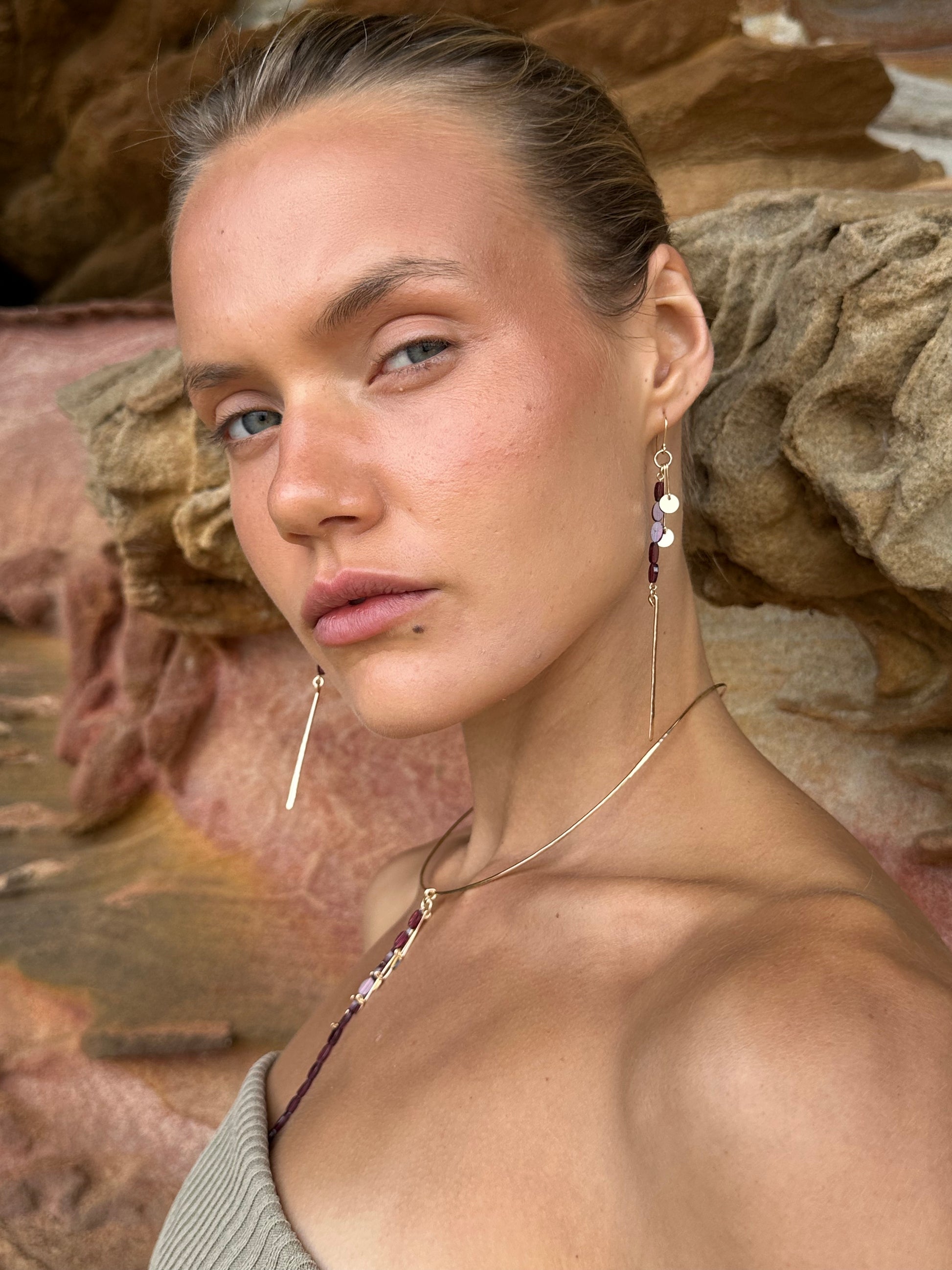Aphrodite drop earrings, garnet earrings, earrings in gold on model